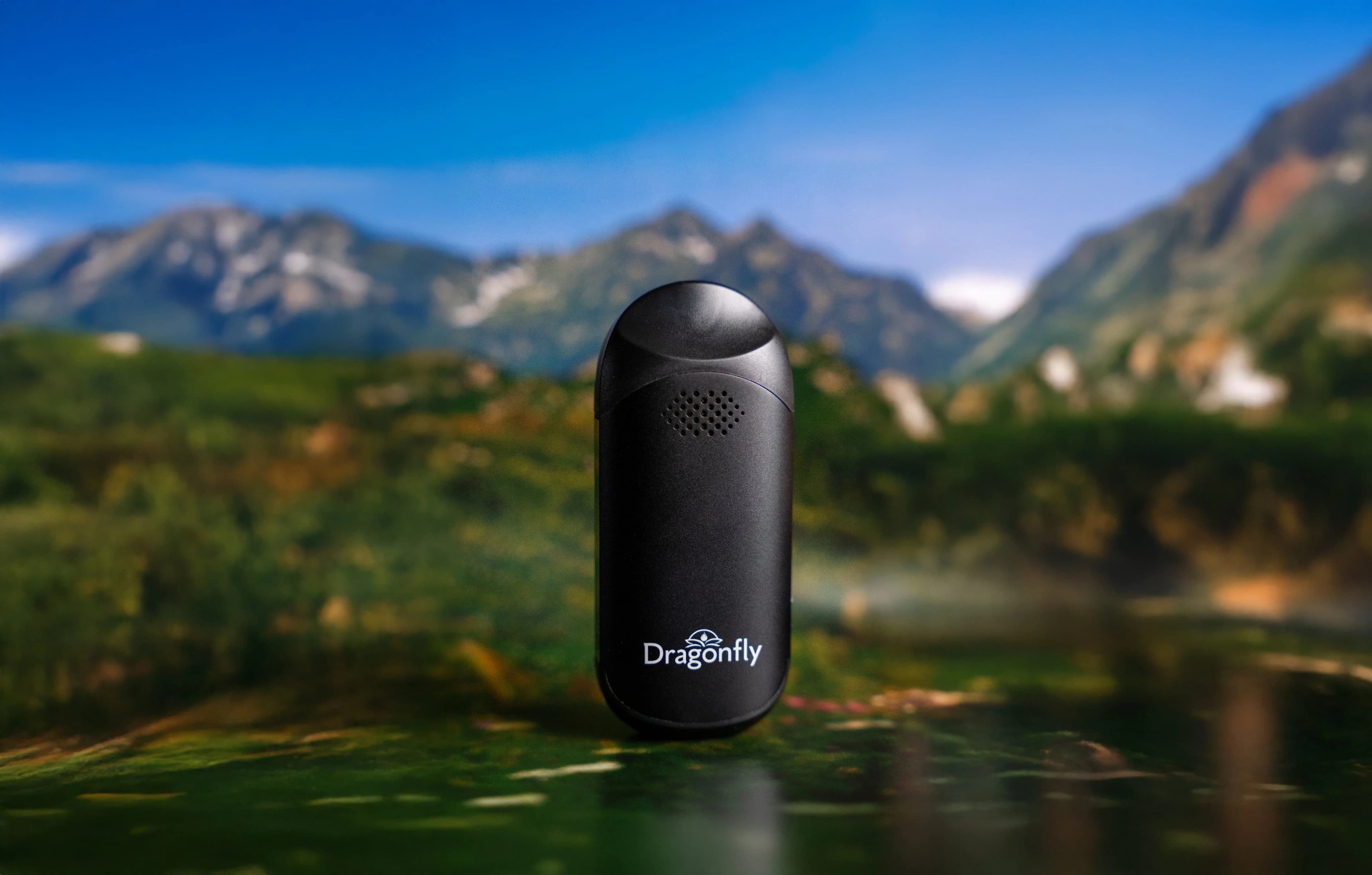 Dragonfly Ember Vaporizer against a mountain range backdrop